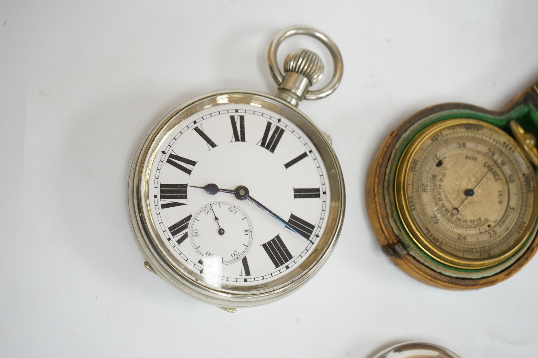 A nickel cased Goliath pocket watch, a Swiss 935 standard half hunter pocket watch and a cased brass barometer. Condition - poor to fair
